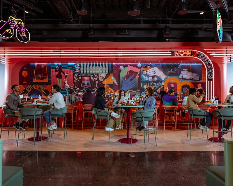 Groups of people sit together and eat at Netflix Bites. 