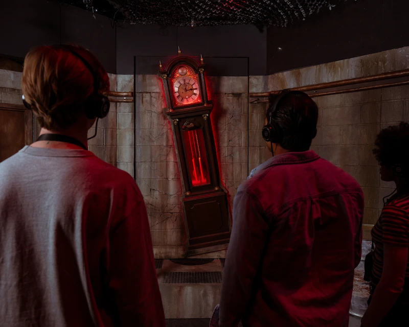 A group of people seeing the iconic clock from Stranger Things in the immersive experience at Netflix House Dallas.