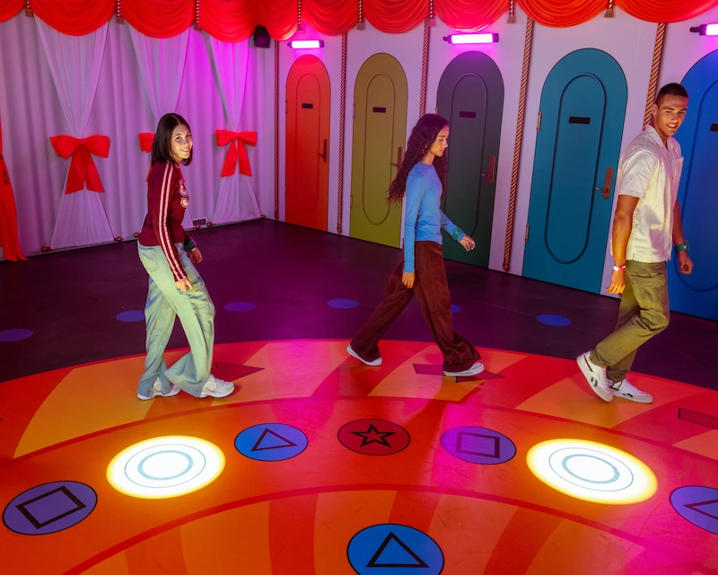 Three friends play the Merry Go Round game in the immersive Squid Game experience. 