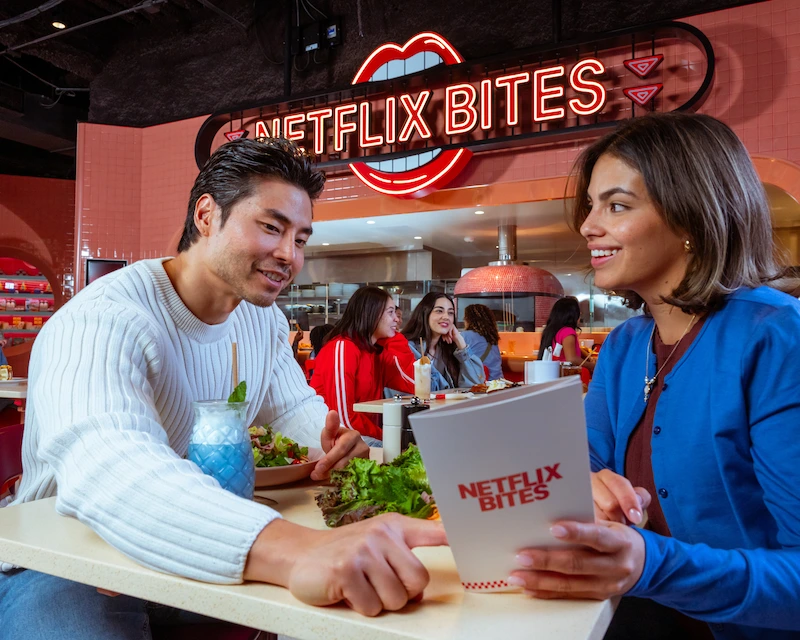 A couple has date night at Netflix Bites and shares a salad. 