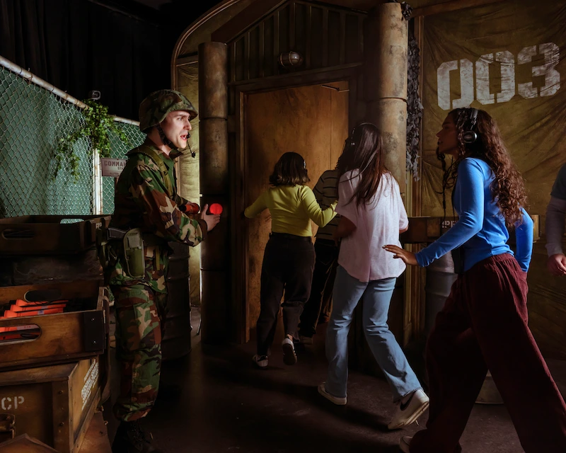 A group of people being ushered into the Stranger Things experience to begin their search of the missing residents of Hawkins.