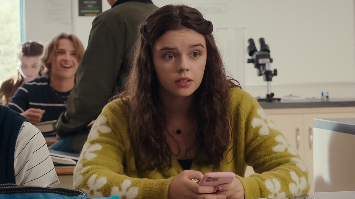Ellie O'Brien nei panni di Grace siede in un'aula con un'espressione nervosa nella prima stagione di "La mia vita con i Walter Boys"