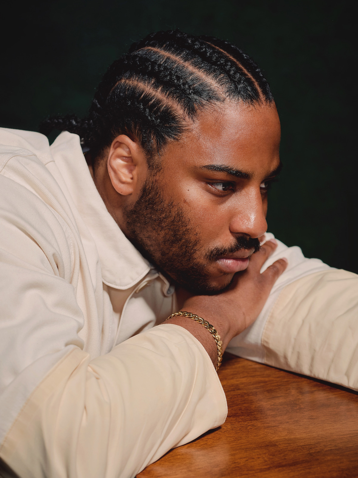 Malcolm Washington wears a white jacket against a dark gray background.