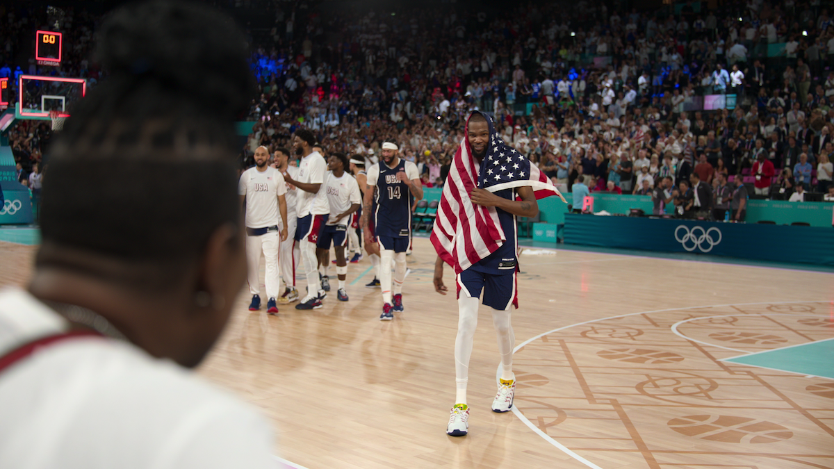 Kevin Durant with the American flag draped over his body after a Team USA Basketball game.