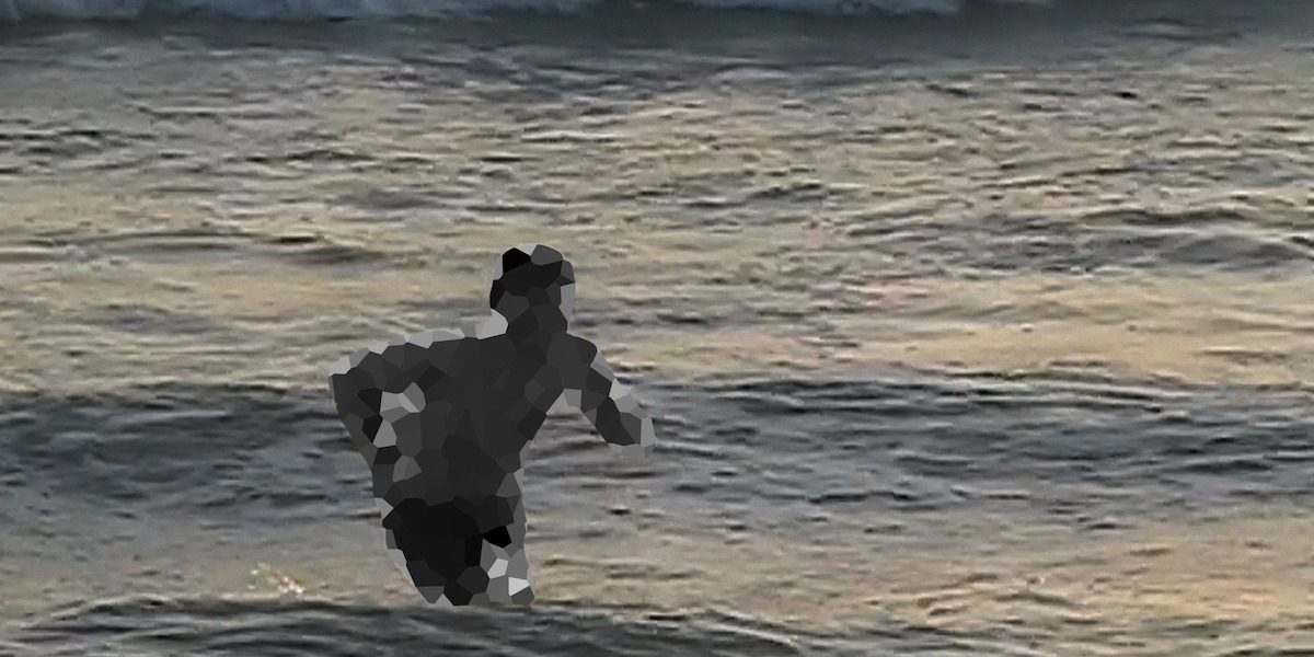 Pixelated person standing in shallow ocean water near the shore at sunset, with gentle waves and soft lighting in the background.