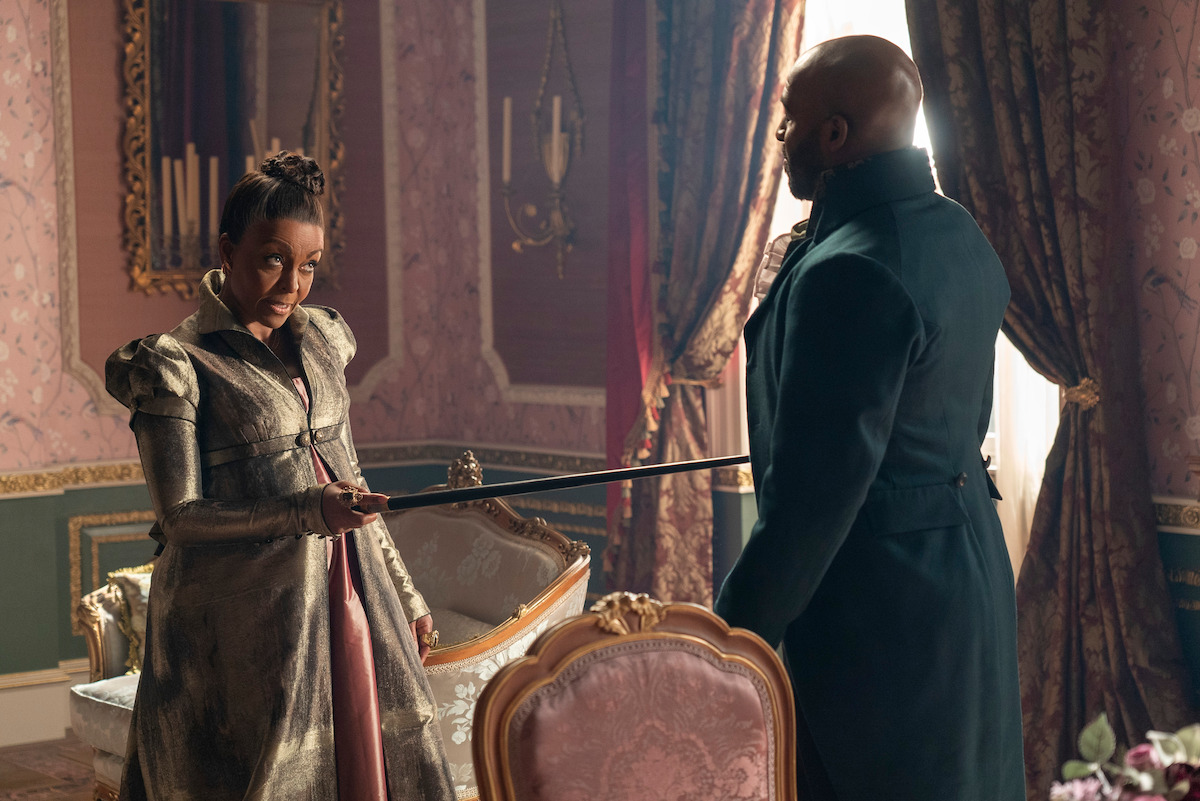 Adjoa Andoh as Lady Agatha Danbury holds her cane up to Daniel Francis as Lord Anderson in Season 3 of ‘Bridgerton.’