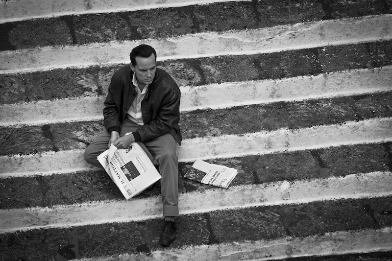 Andrew Scott as Tom Ripley seated on steps in 'Ripley'