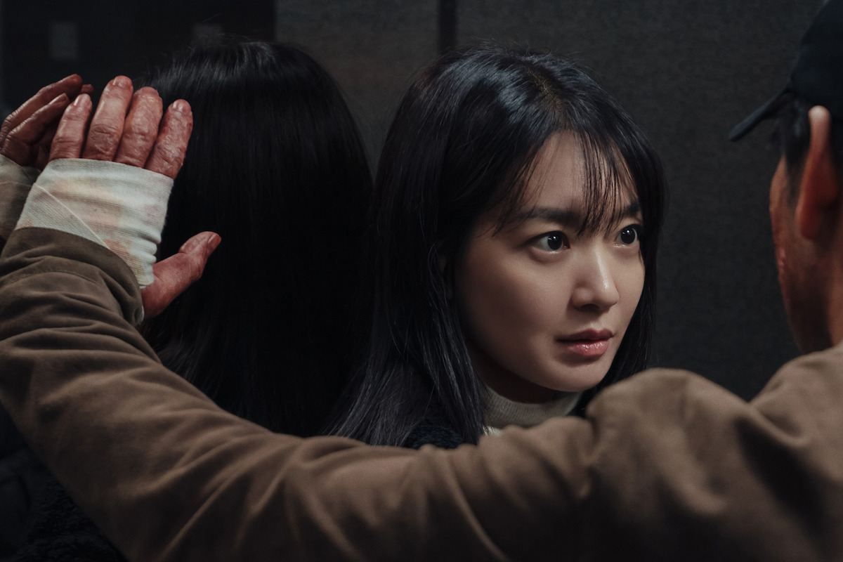In an image from the series ‘Karma,’ a man presses a bandaged left hand against an elevator wall next to Shin Min-a’s head.