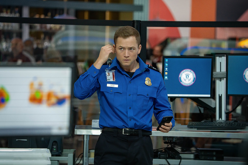 Taron Egerton as Ethan Kopek in airport security uniform.