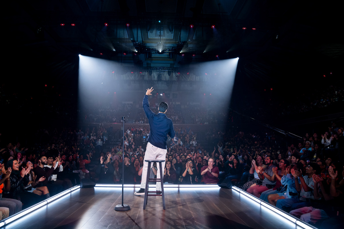 Hasan Minhaj waves to the crowd during his stand-up special.