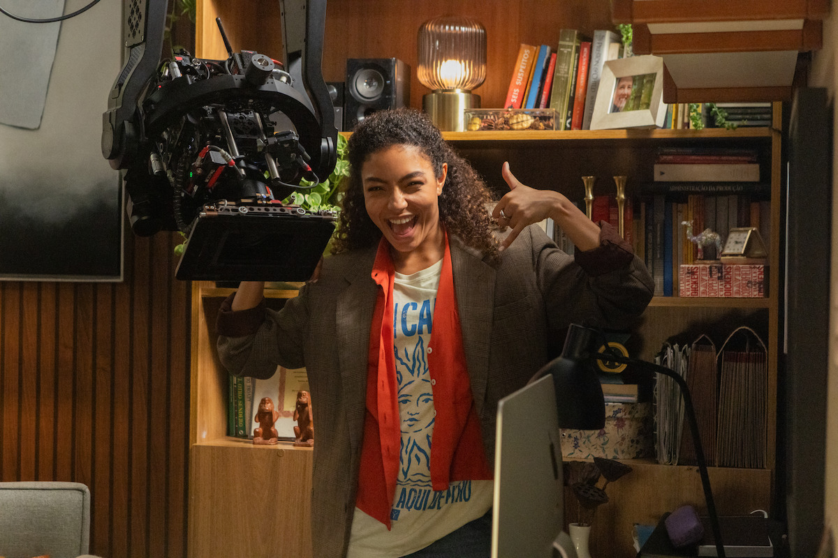 Uma mulher, a atriz Any Gabrielly, aparece próxima a uma câmera no set de filmagem da série ‘Habeas Corpus’