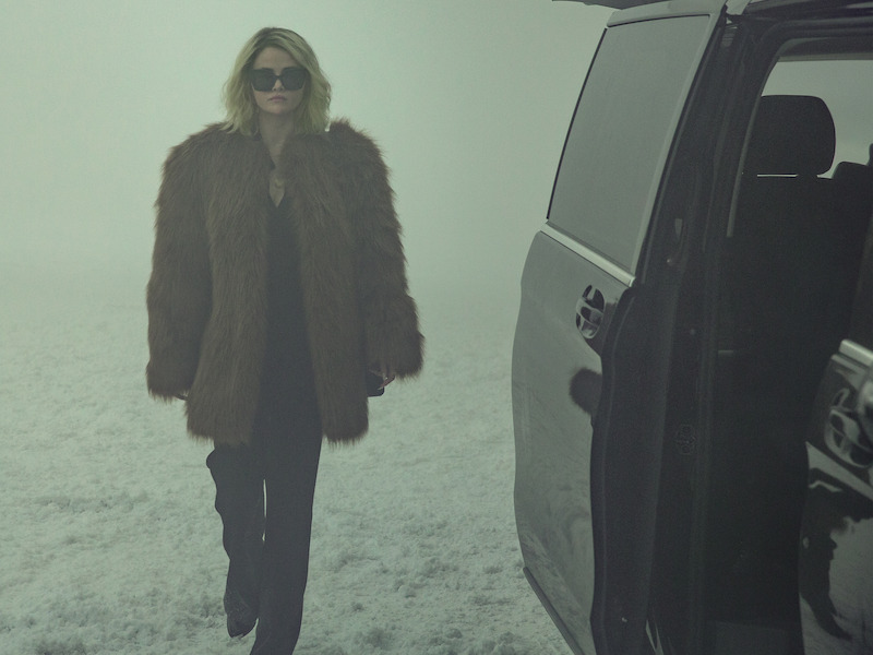 Jessi (Selena Gomez) wears a fur jacket and walks through the snow.