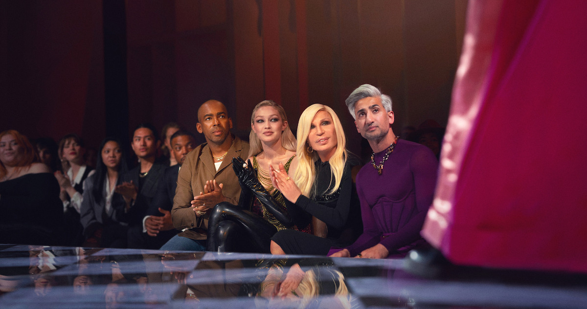 Jason Bolde, Gigi Hadid, Donatella Versace and Tan France watch a runway show. 