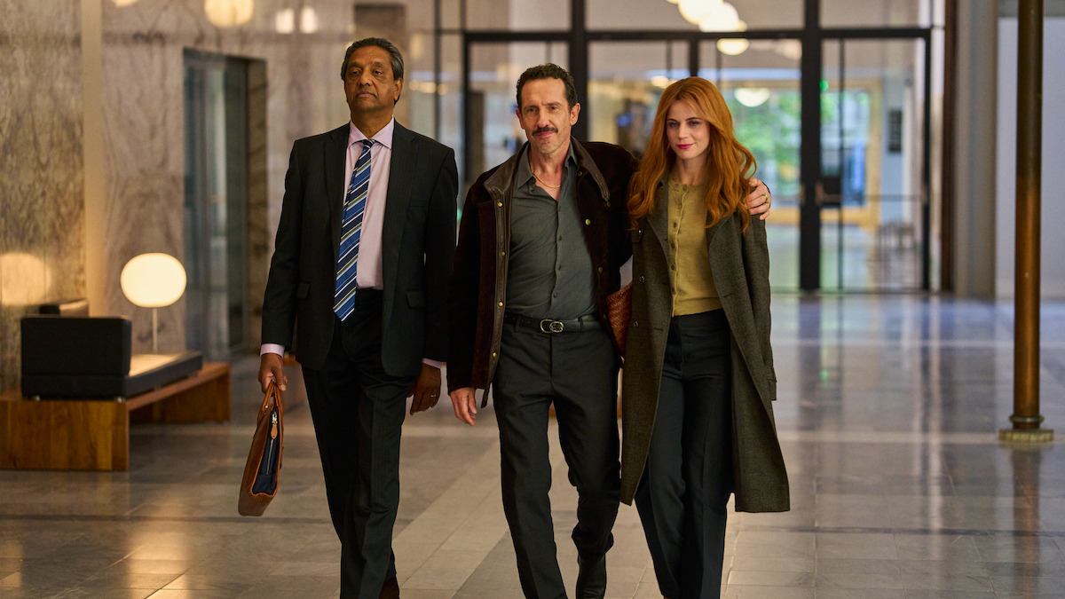 Elise Schaap as Marjolein Hofman and Jacob Derwig as Jack van Doorn walk down the hall with a lawyer in ‘Amsterdam Empire.’