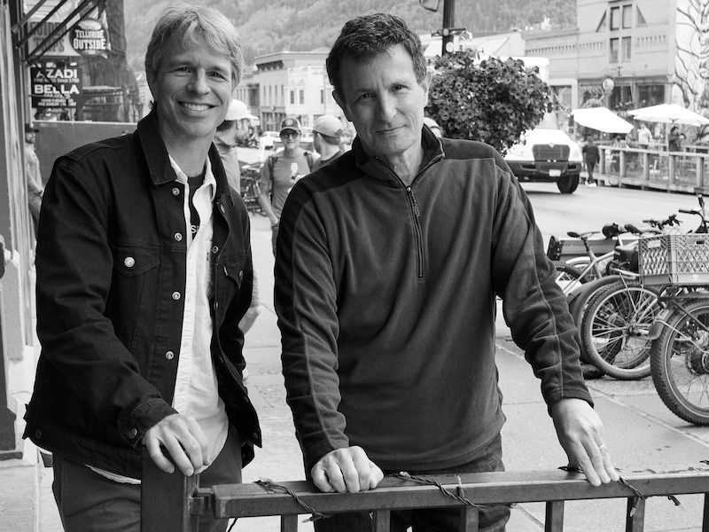 Marshall Curry and David Remnick smile as they pose together.