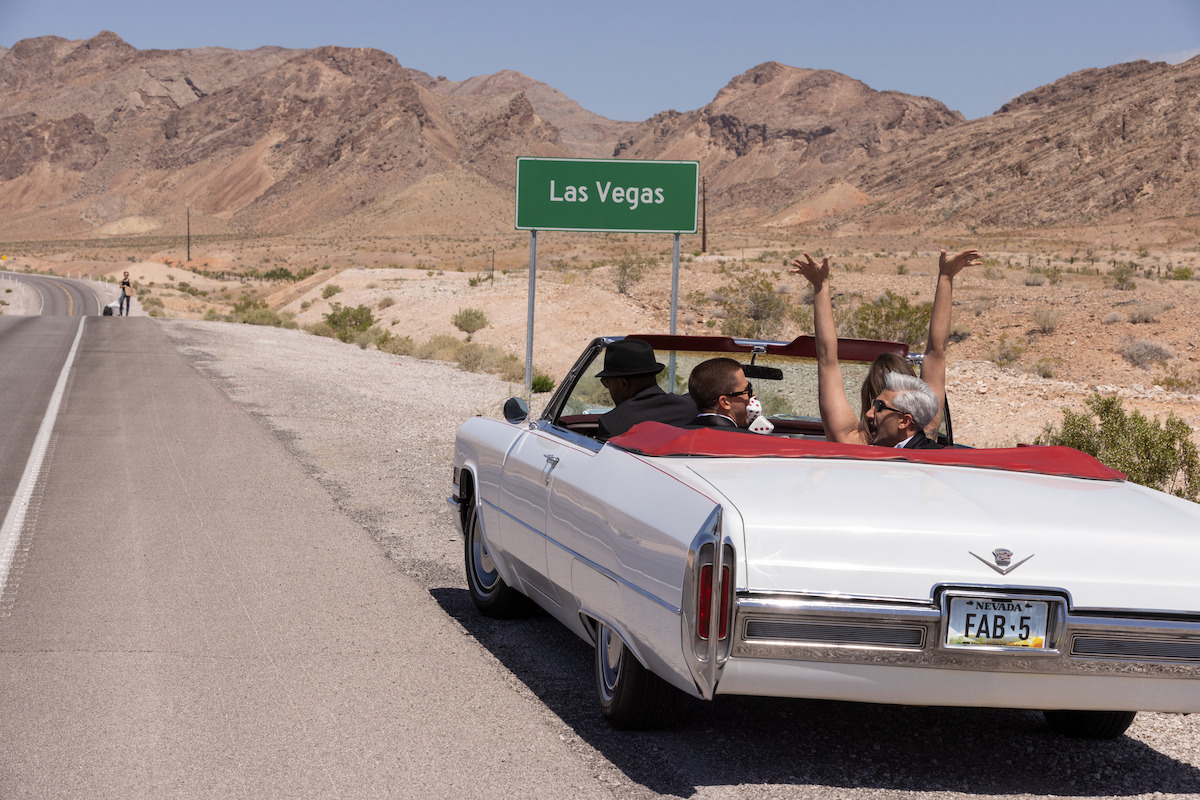 Jeremiah Brent, Karamo Brown, Antoni Porowski, Jonathan Van Ness, and Tan France in a car with a Las Vegas sign in front of them.