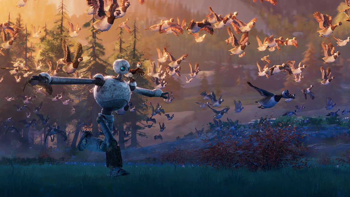A still image from ‘The Wild Robot’ depicts a robot running through a field with a flock of birds.