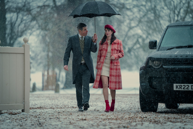 Scodelario walks with a man holding an umbrella over her in Season 1 of ‘The Gentlemen.’