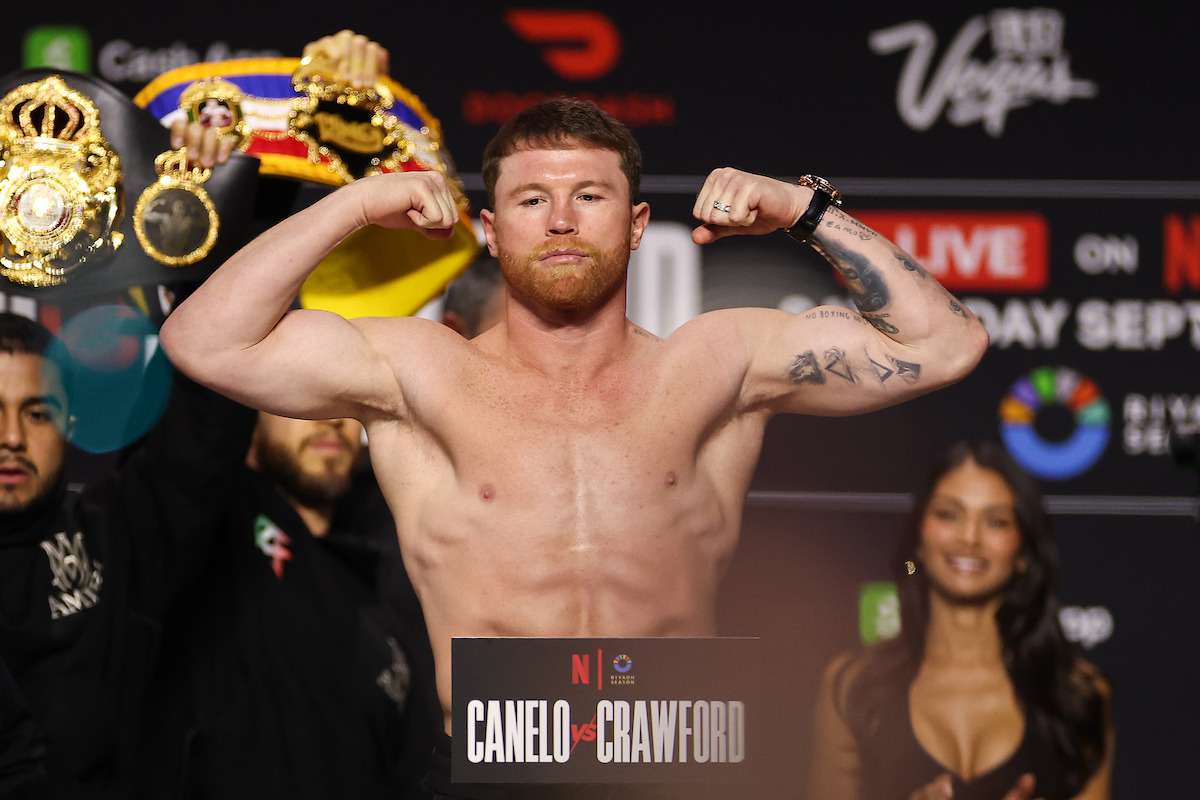 Undisputed super middleweight champion Canelo Alvarez poses on the scale during a weigh-in ahead of his undisputed super middleweight title fight at T-Mobile Arena.