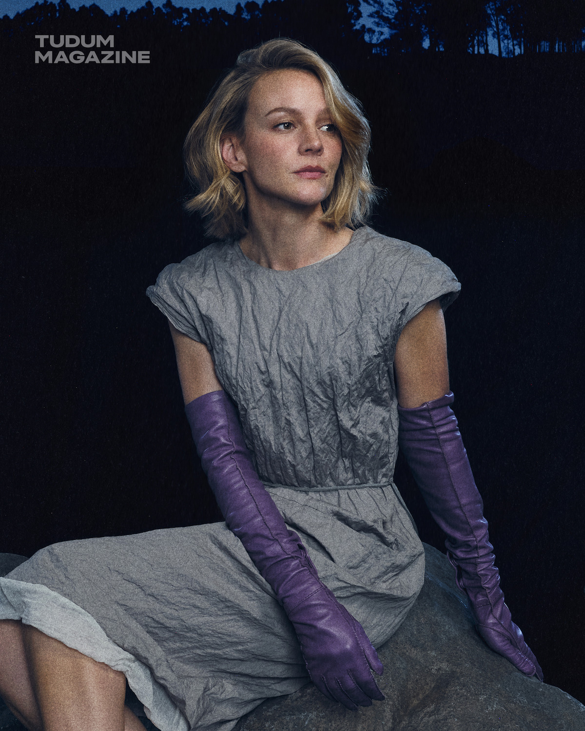 Carey Mulligan in a gray dress and purple elbow length gloves