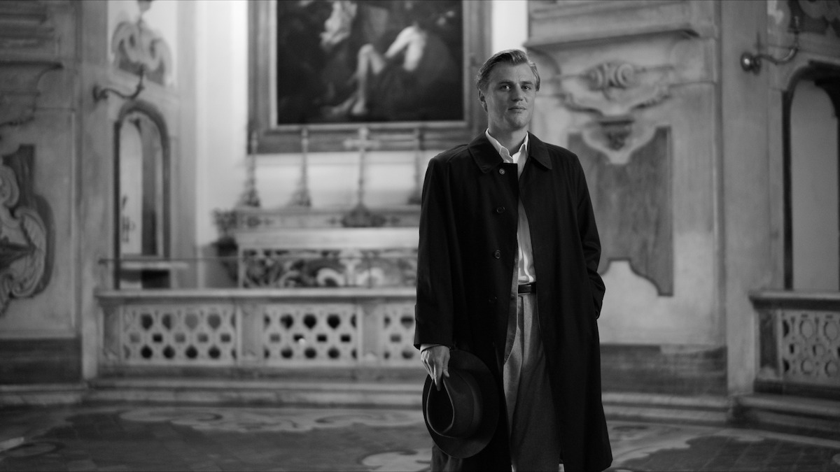 Johnny Flynn as Dickie Greenleaf stands in a church in ‘Ripley’
