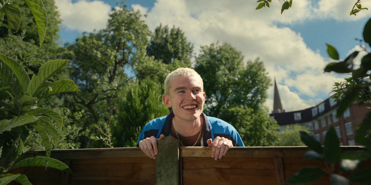 Harry Cadby as Cam peeks over a fence in Season 1 of ‘Everything Now.’