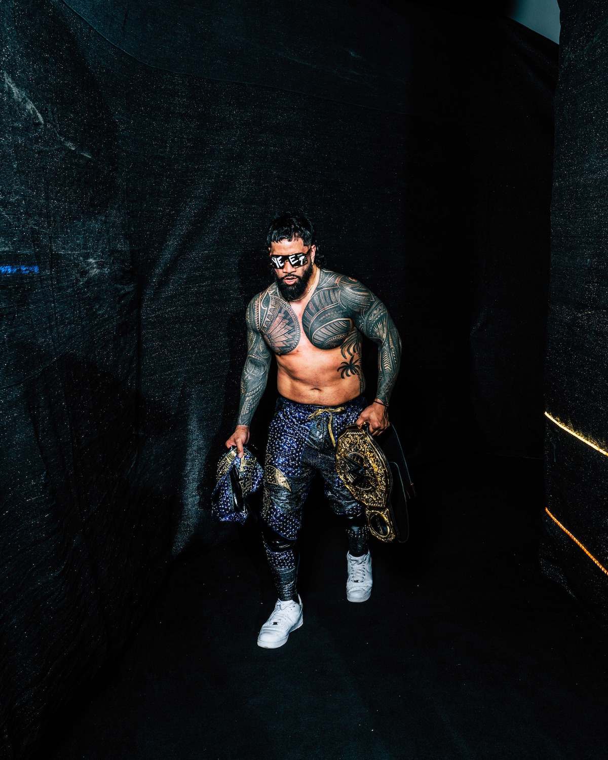 Jey Uso entering the arena with his belt.