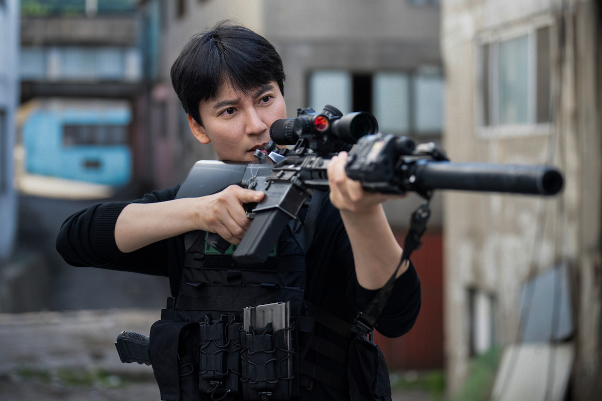 Kim Nam-gil as Lee Do holds up an automatic weapon in ‘Trigger.’