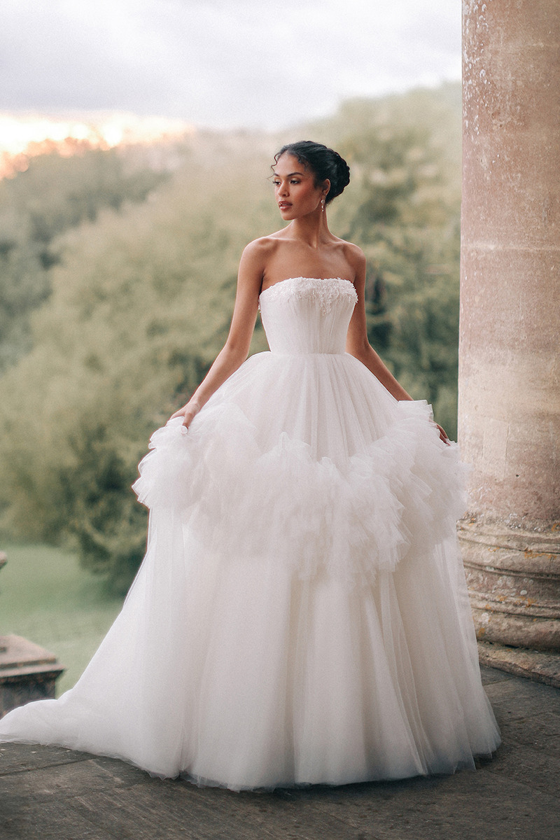 Woman in strapless bridal dress looks to her right and poses.
