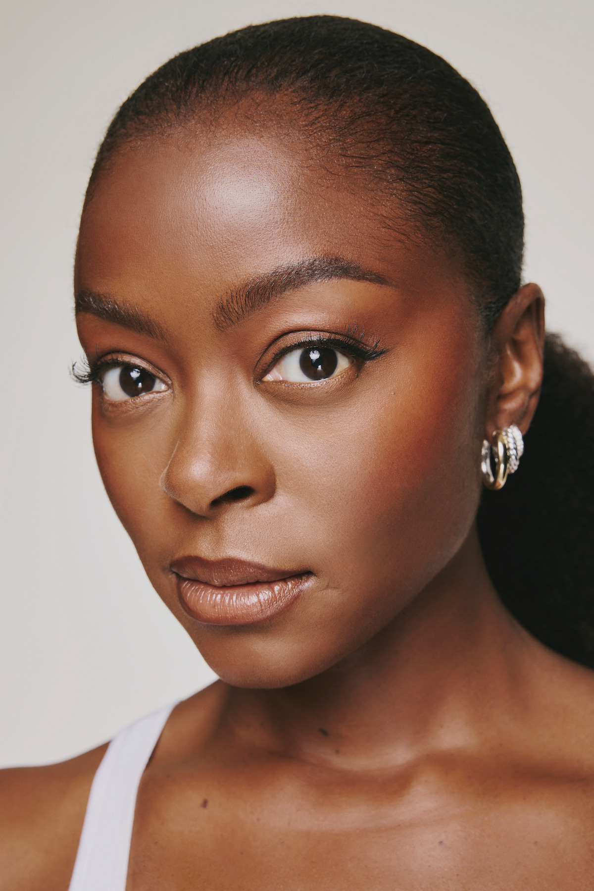 Danielle Deadwyler wears a white tank in an up close shot.