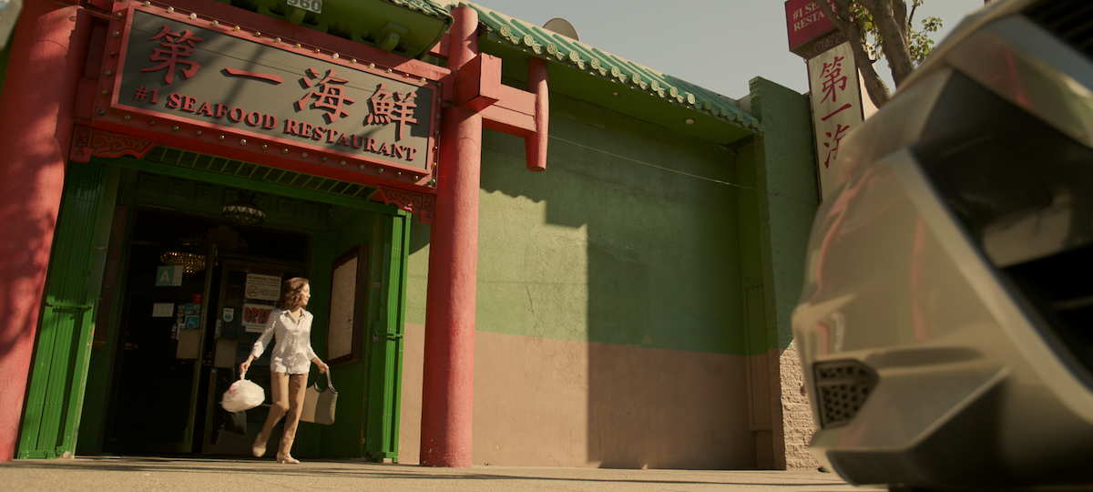 Michelle Yeoh as Eileen Sun walks out of a restaurant holding a grocery bag in season 1 of ‘The Brothers Sun’