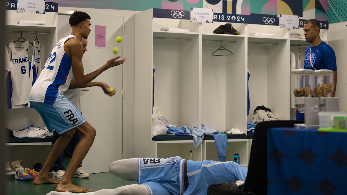 Victor Wembanyama juggles tennis balls in the locker room.