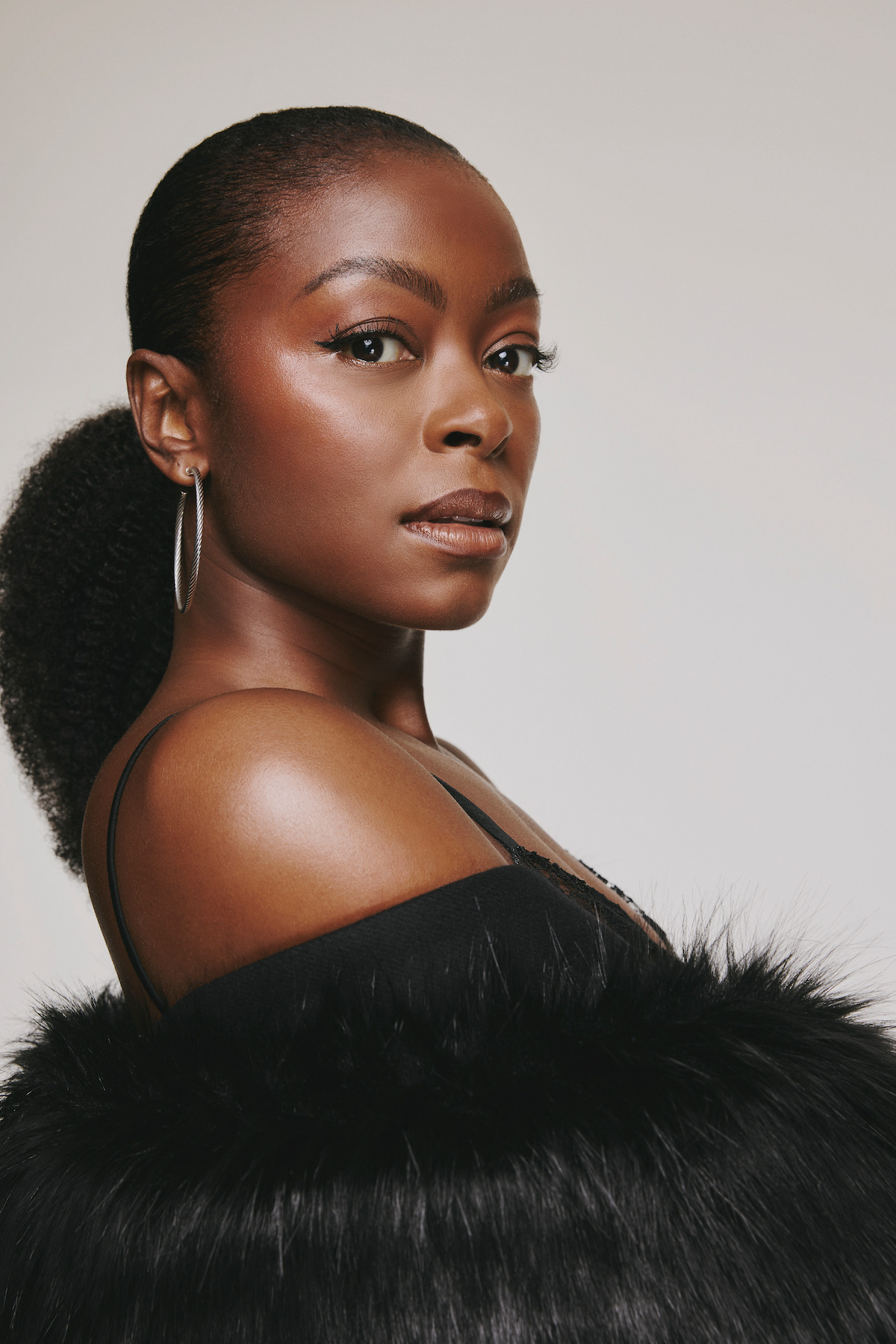 Danielle Deadwyler wears a black sleeveless top in half profile.