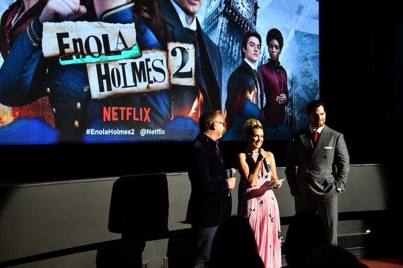 Director Harry Bradbeer, Millie Bobby Brown, and Henry Cavill introduce Enola Holmes 2 to the audience.
