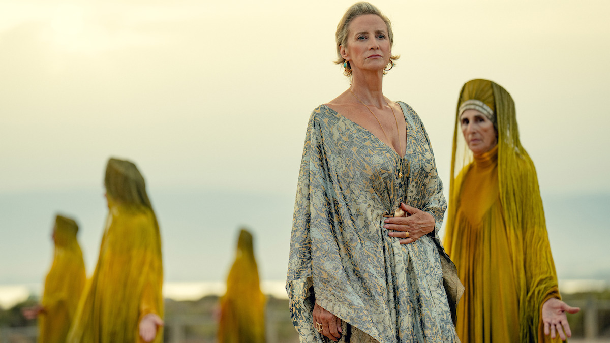Janet McTeer as Hera walks on a beach with women in golden robes walking around her in Season 1 of ‘Kaos’