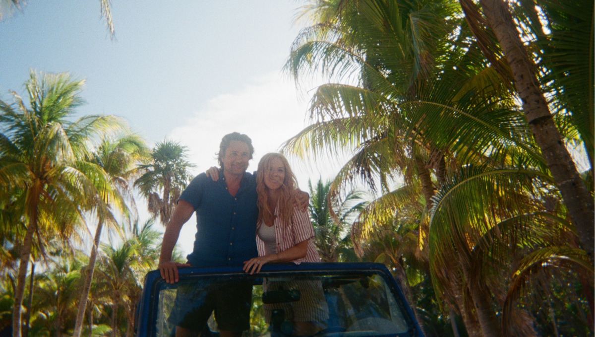 Mel and Jack standing arm in arm in a Jeep while in Tulum on their honeymoon