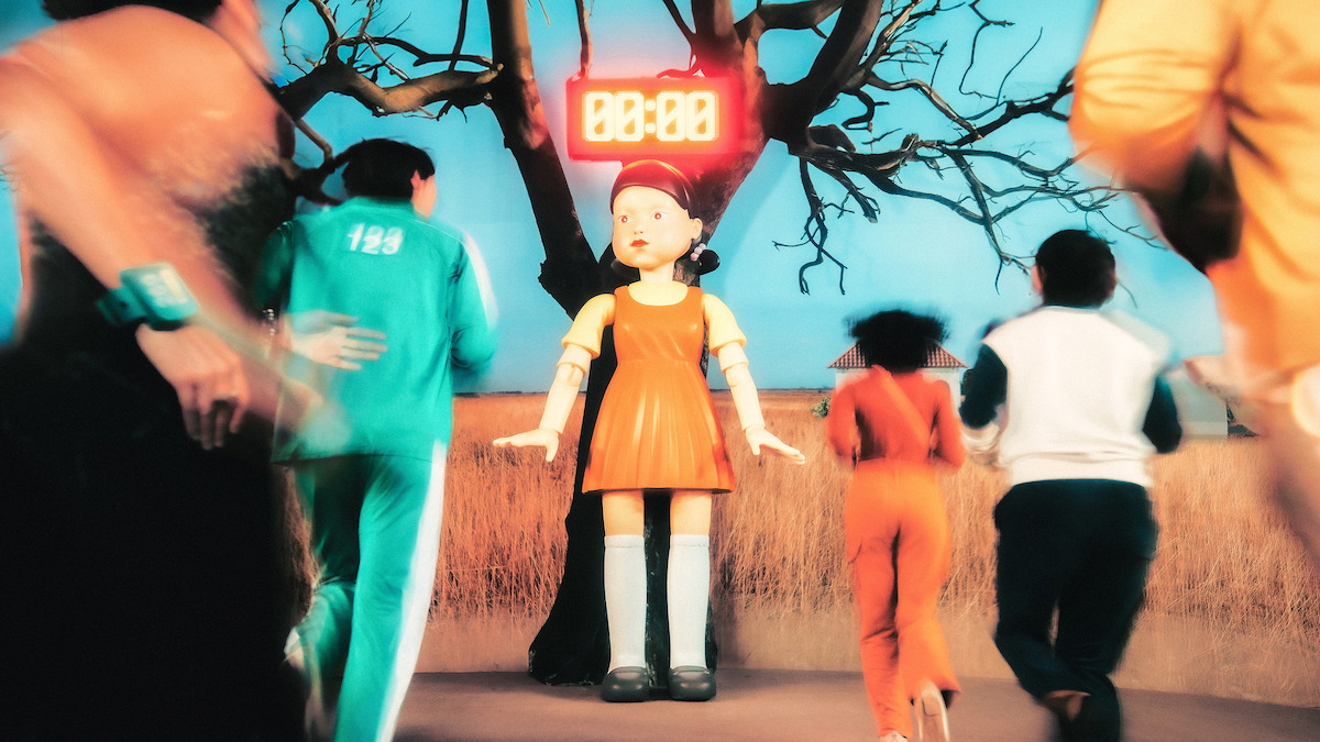 People in plain clothes run toward the 'Squid Game' doll