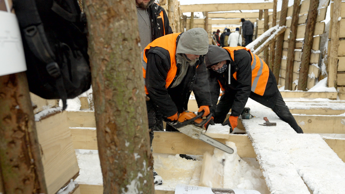 A construction crew saws a piece of wood to reinforce the trenches for 'All Quiet on the Western Front.'