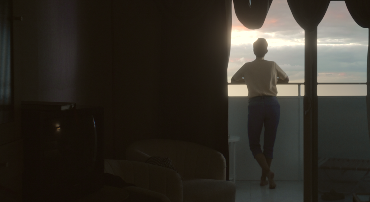 A woman looks over a ship’s balcony.
