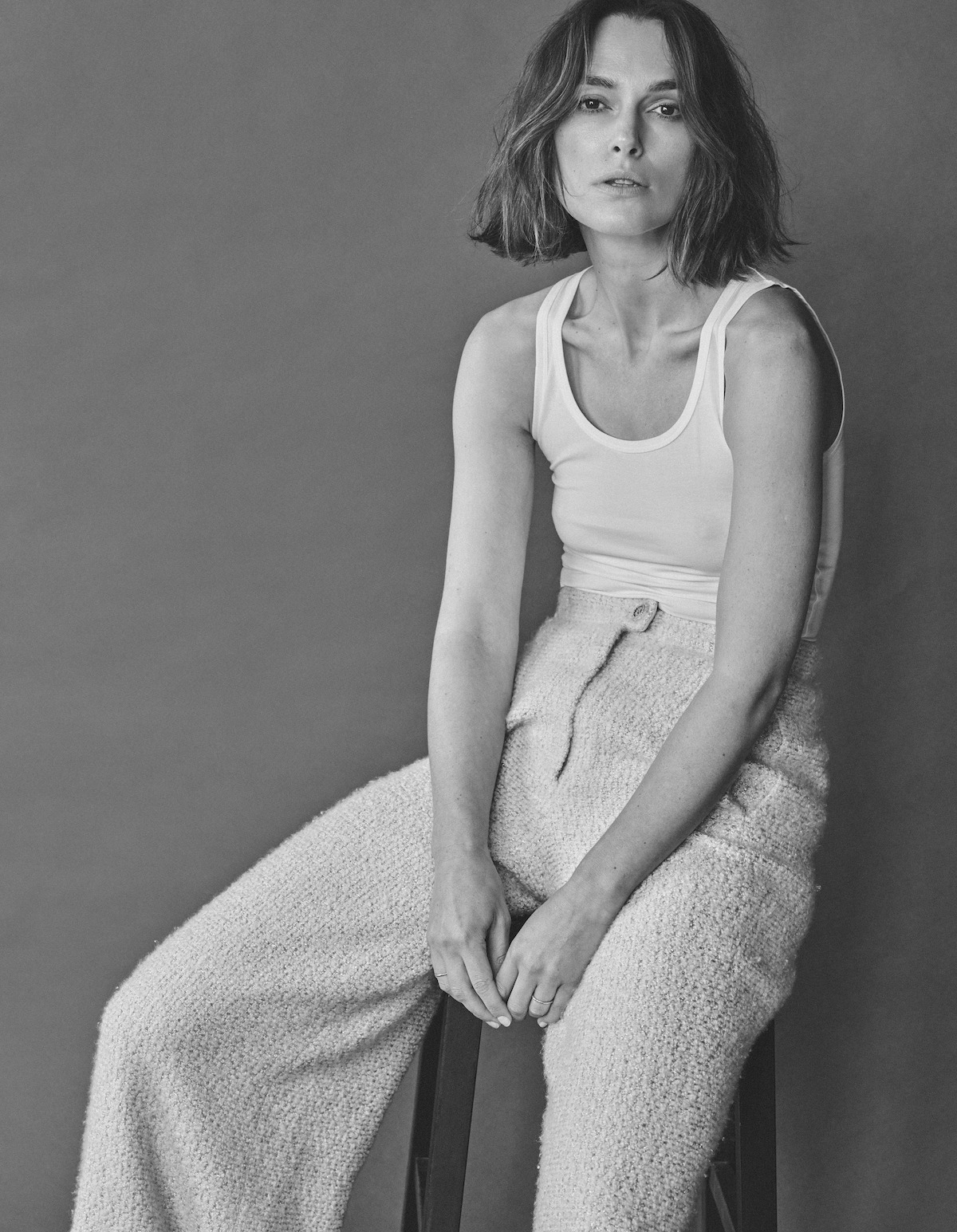 Keira Knightley wears a white tank and knit pants.