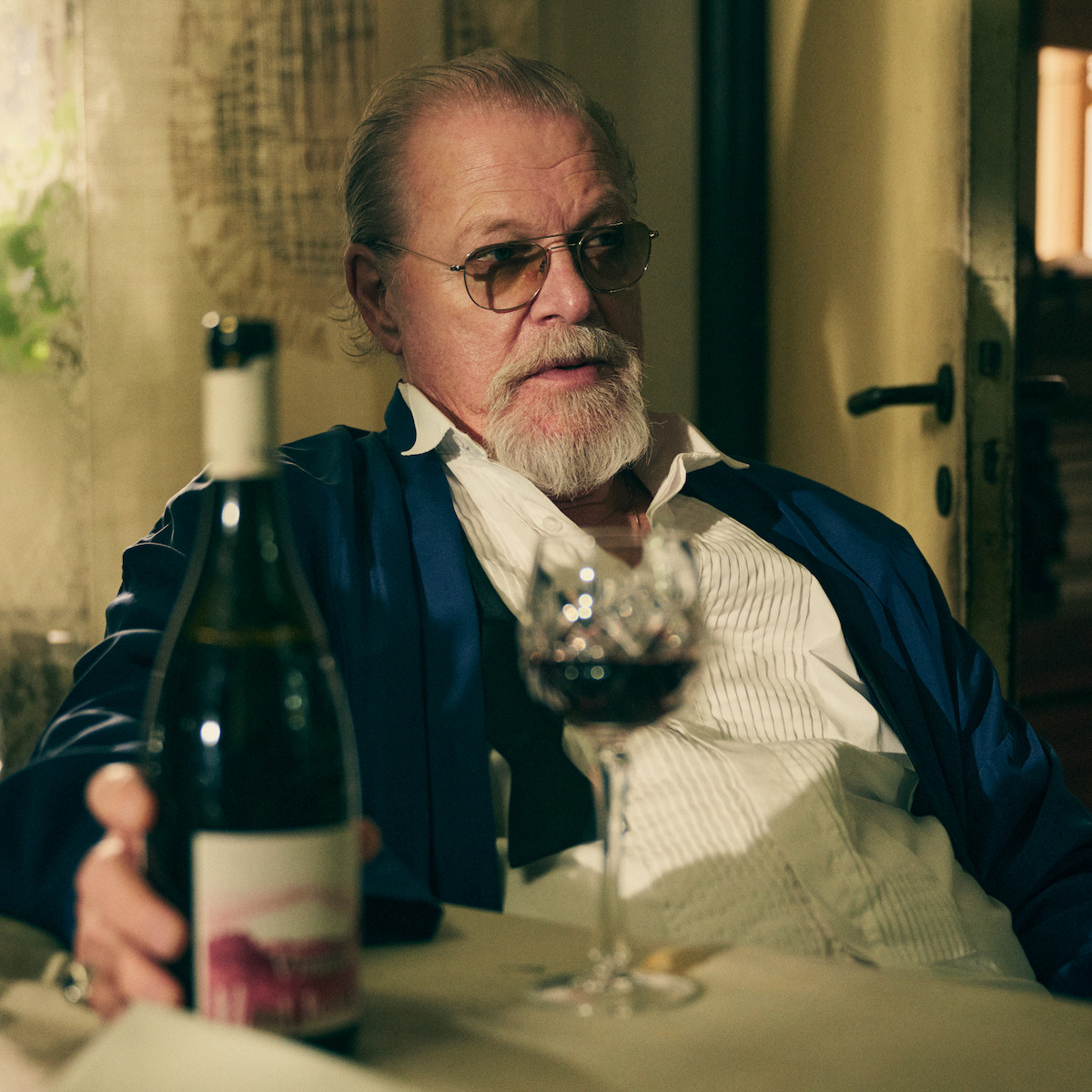 Peter Andersson as Charles drinking wine at the dinner table in a production still from ‘An Honest Life.’
