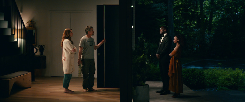 (2023) Julia Roberts as Amanda, Ethan Hawke as Clay standing in the foyer of their home while Mahershala Ali as G.H. and Myha’la as Ruth stand outside in a tux and evening gown. 