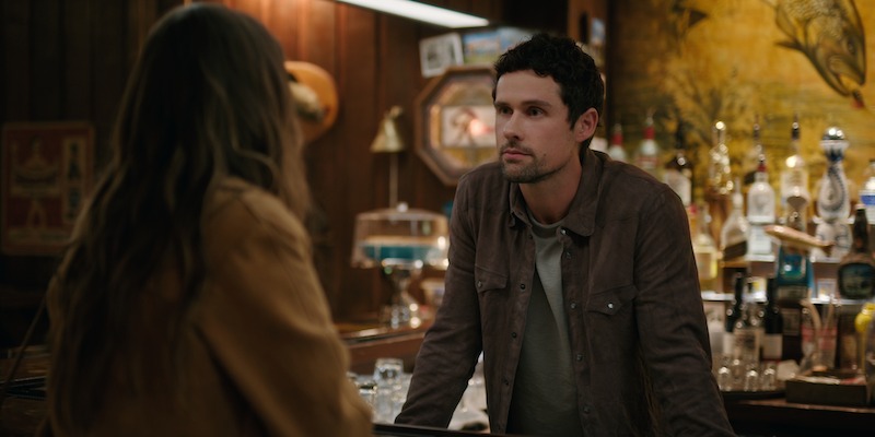 Ben Hollingsworth as Dan Brady leans over a bar in Season 6 of 'Virgin River'