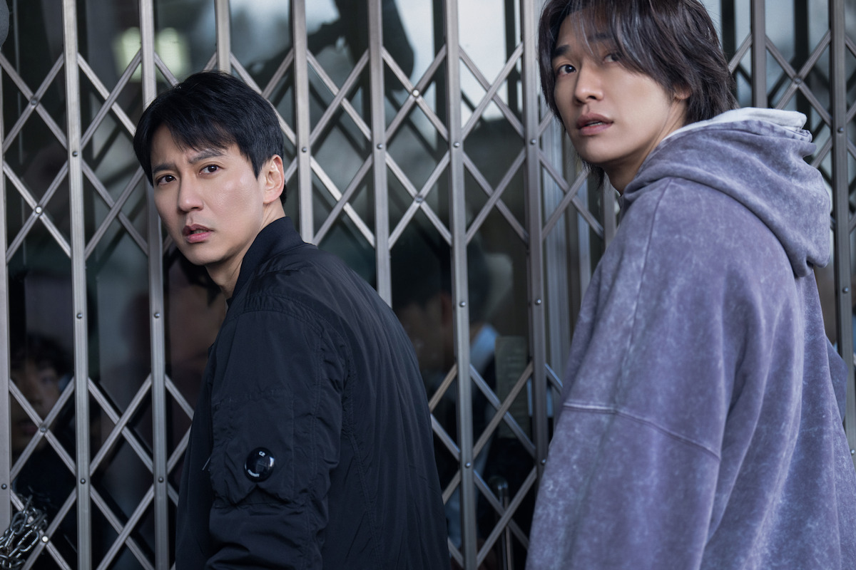 Kim Nam-gil as Lee Do and Kim Young-kwang as Moon Baek each look over their shoulders in an image from the series ‘Trigger’
