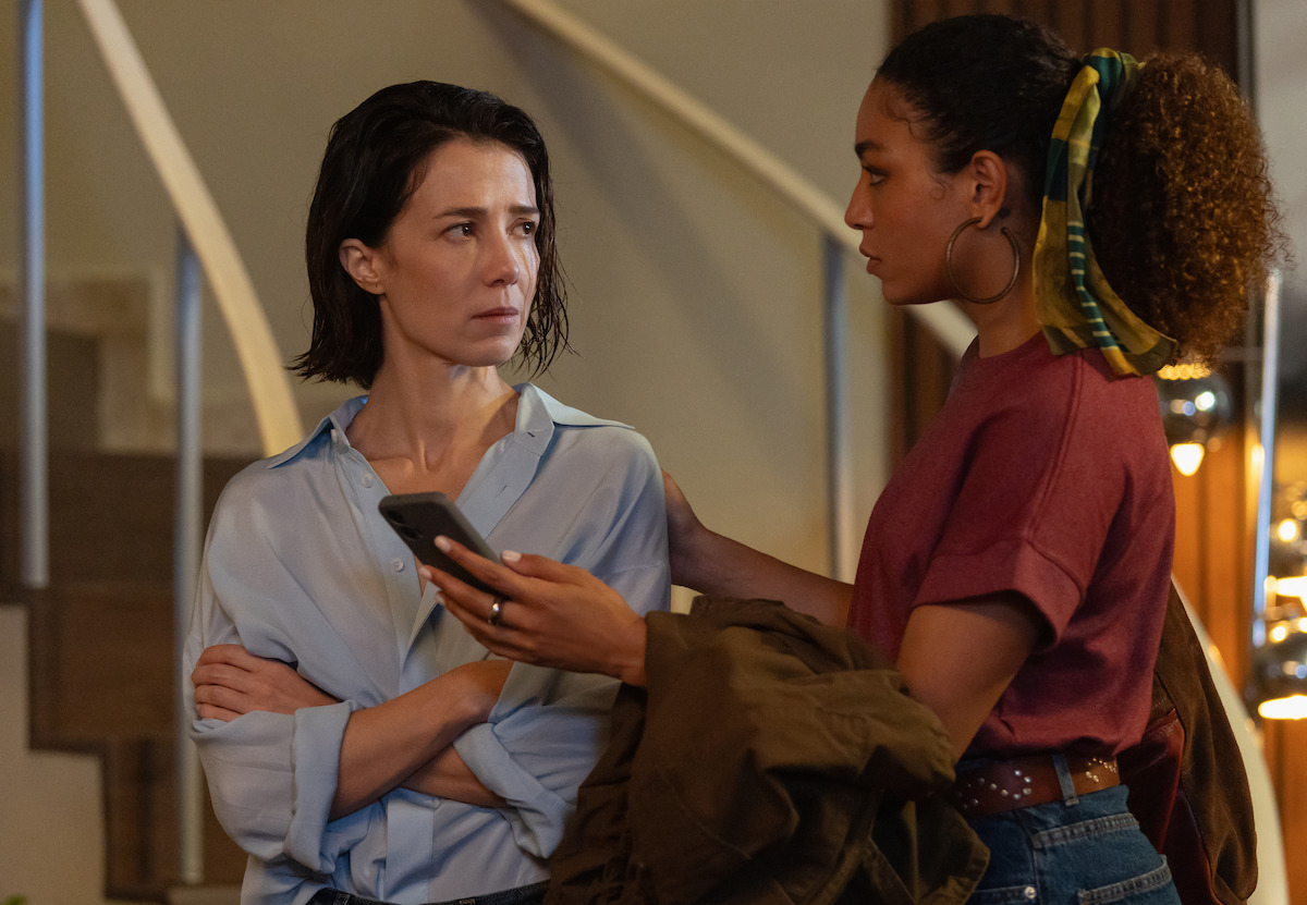 Duas mulheres olhem para um celular com expressões de preocupação