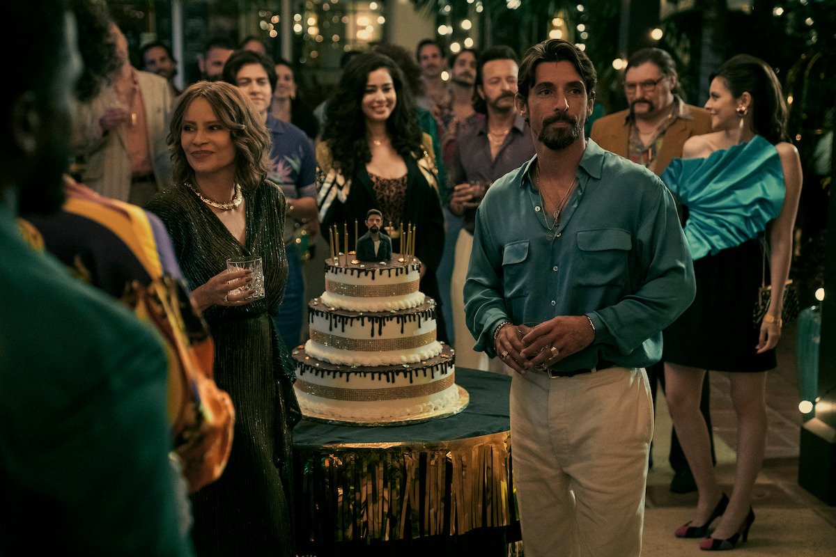 Sofia Vergara as Griselda and Alberto Guerra as Dario stand in front of a birthday cake at a party.