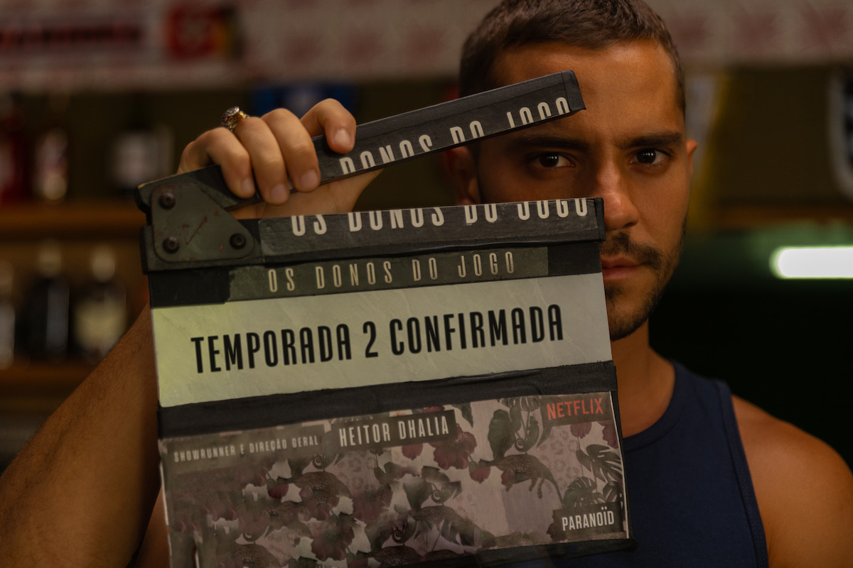 André Lamoglia segura uma claquete em que se lê: “Temporada 2 confirmada”