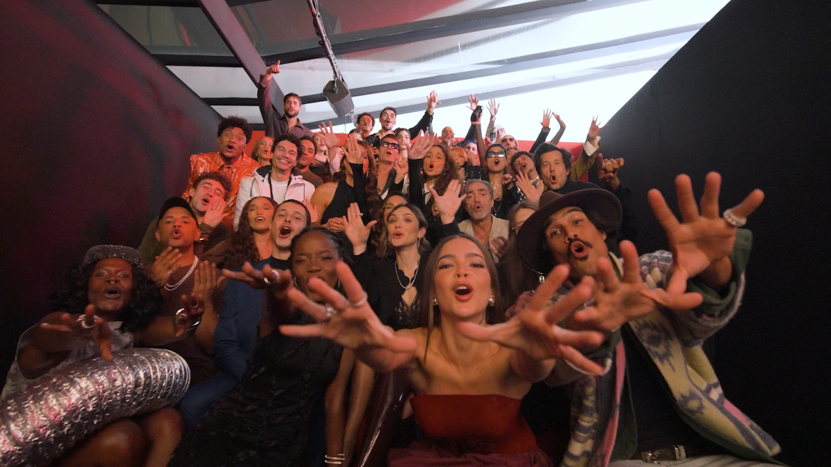 Grupo de atores e atrizes tiram foto em um auditorio durante a festa de 15 anos de Netflix