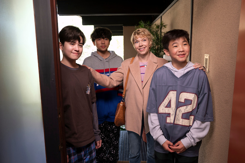 Lincoln Lambert as Nico, Wyatt Young as Wyatt, Mary Elizabeth Ellis as Emily, and Deuce Basco as Jace stand in a doorway smiling in Season 1 of 'A Man on the Inside'