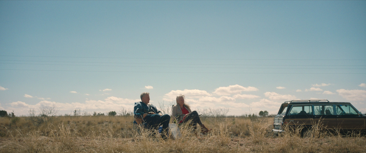 Will Ferrell and Harper Steele sit in lawn chairs on a grassy expanse.